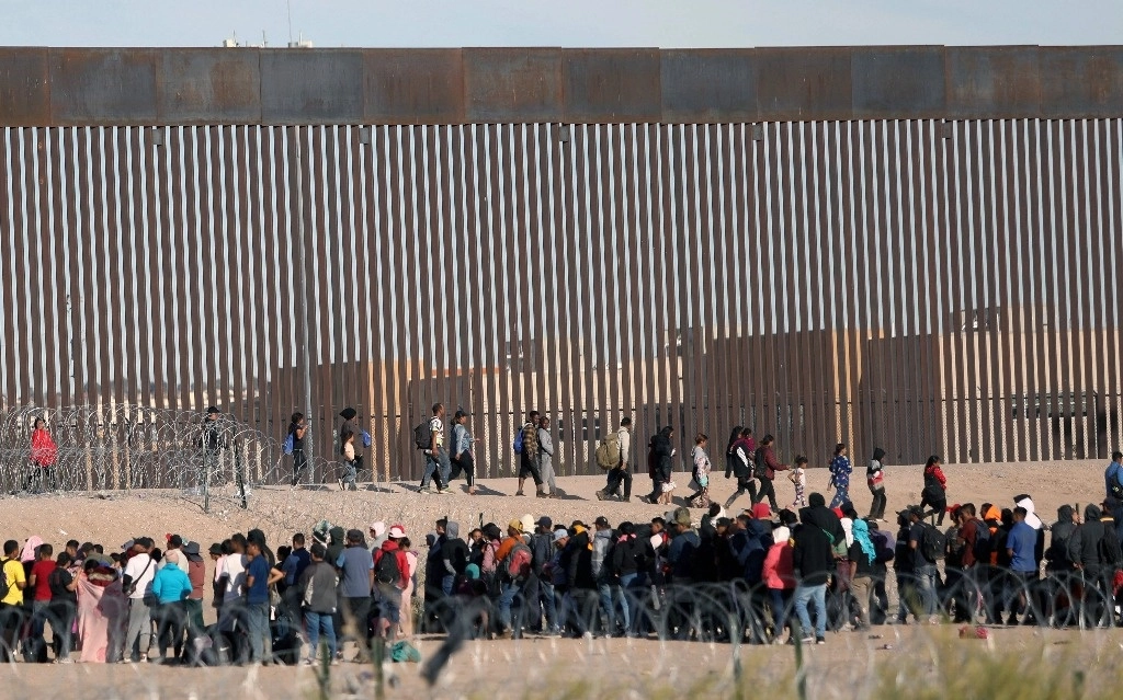 Migrantes solicitantes de asilo esperan ser procesados ​​por la Patrulla Fronteriza de Estados Unidos luego de haber cruzado el Río Grande desde Ciudad Juárez. Foto Afp