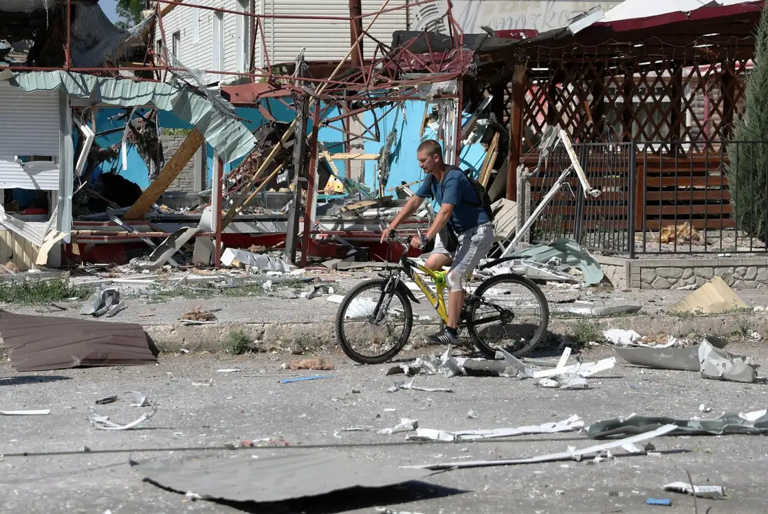 Un hombre pasa en bicicleta junto a viviendas destruidas en Lysychansk, Ucrania, el 21 de junio de 2022. Foto Afp