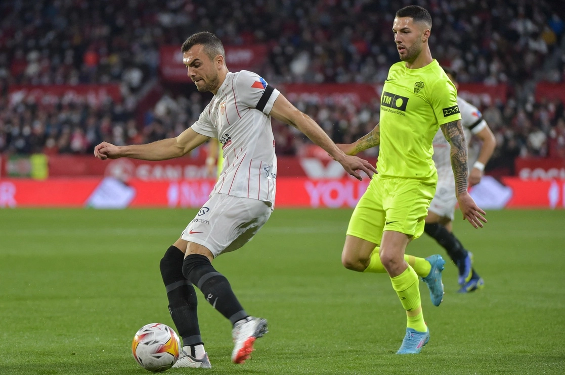 Joan Jordán Moreno de la escuadra del Sevilla controla el esférico frente al ‘Tete’ Morente del Elche, en la fecha  24 de La Liga. Foto Afp 