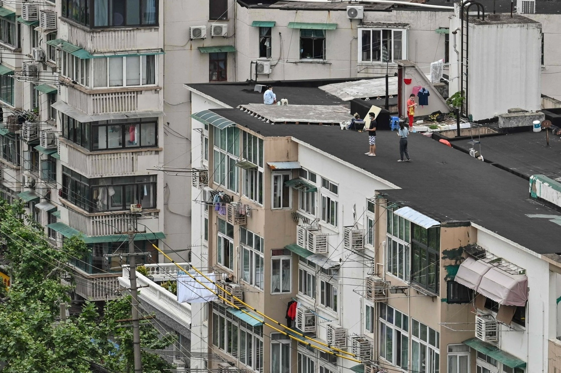 Vecinos sobre el techo de un edificio, durante el estricto confinamiento contra el coronavirus en Shanghai. Foto Afp
