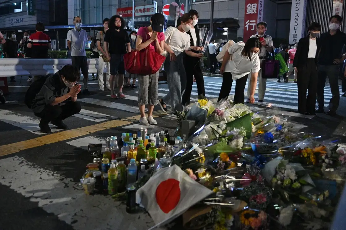 Ciudadanos japoneses rinden homenaje al asesinado ex primer ministro Shinzo Abe, en un improvisado memorial fuera de la Estación Yamato-Saidaiji, cerca de donde el político fue baleado en la ciudad de Nara, el 8 de julio de 2022. Foto Afp