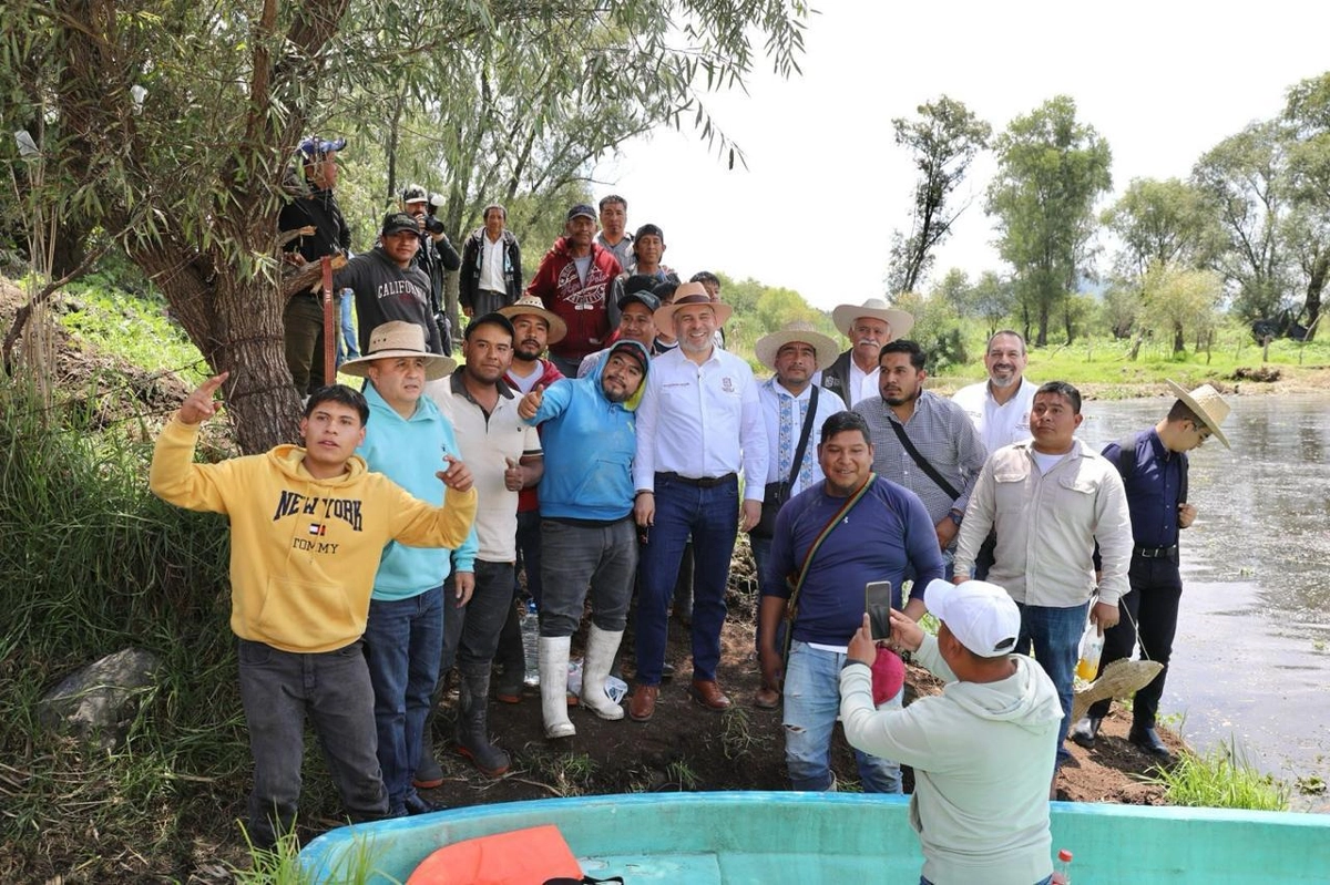Personal de la Comisión de Pesca de Michoacán durante la siembra de peces blancos. Foto