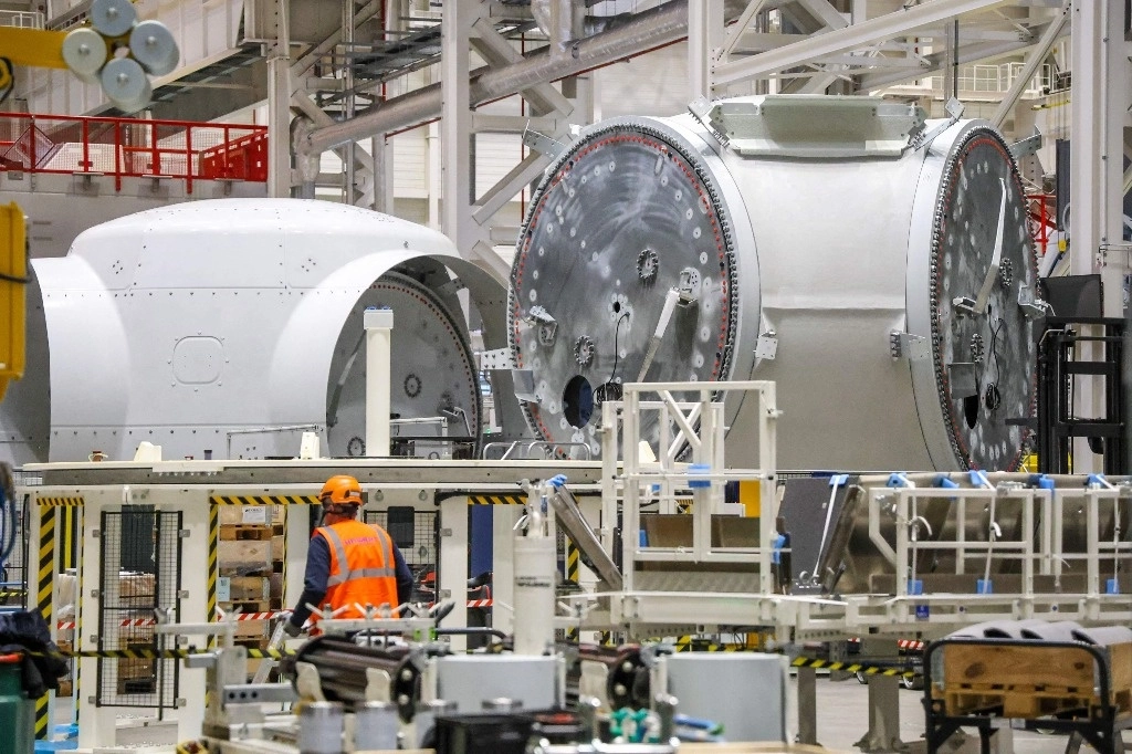 Un trabajador se encuentra junto a los bujes de rotor de turbinas eólicas en la fábrica de Siemens Gamesa en Cuxhaven, noroeste de Alemania, el 31 de enero de 2023. Foto Afp