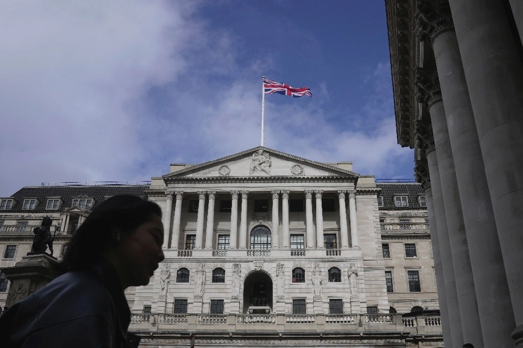 Una mujer camina frente al Banco de Inglaterra, en el distrito financiero de Londres. Foto Ap