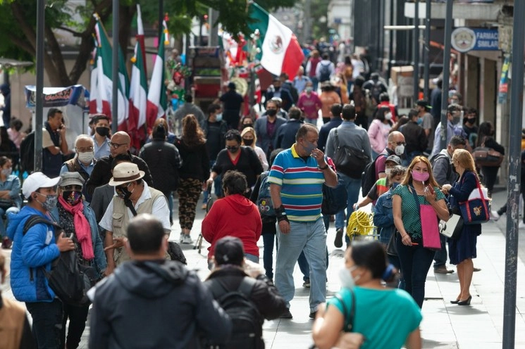 Decenas de peatones atraviesan la avenida Juárez mientras vendedores ambulantes de adornos con motivos patrios despliegan sus banderas mexicanas, en el Centro Histórico, el 4 de septiembre de 2020. Foto Pablo Ramos