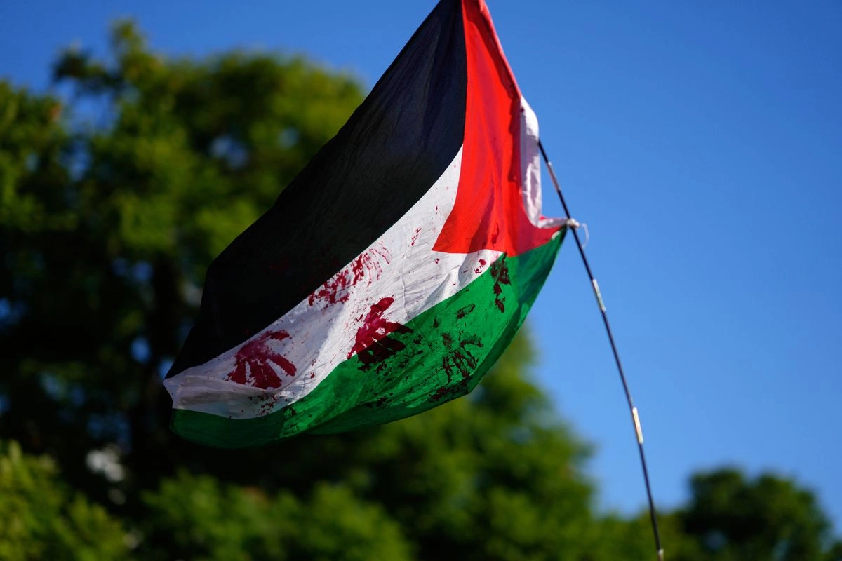 Una bandera palestina teñida con pintura roja ondea durante una manifestación pro palestina en solidaridad con la Flotilla Global Sumud después de que sus barcos fueran interceptados por la marina israelí, en Lisboa, el sábado 4 de octubre de 2025. Foto 