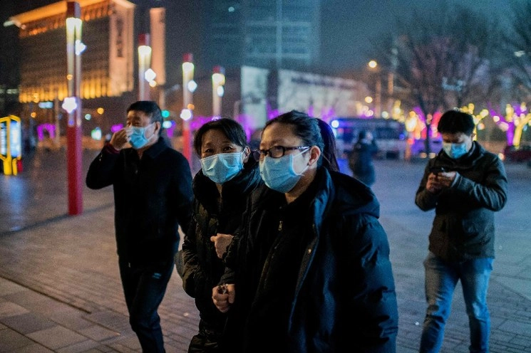 Ciudadanos chinos caminan por las calles de Beijing este 28 de enero de 2020. Foto Afp