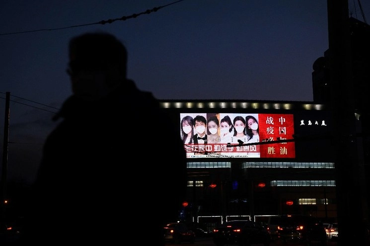 Una pantalla gigante muestra un eslogan de apoyo que dice "Vamos China; prevalece contra la epidemia" en un edificio en Beijing. Foto Afp