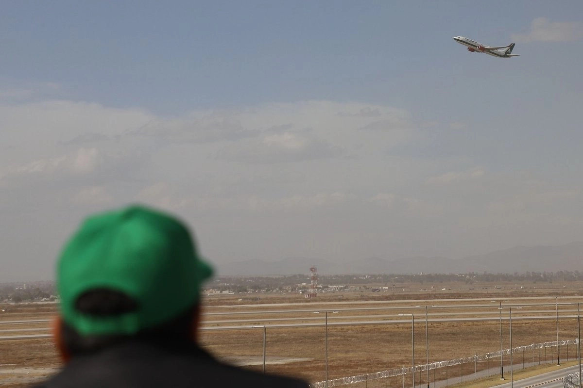 Una persona observa el despegue de un avión de la aerolínea Mexicana de Aviación desde el mirador del AIFA.