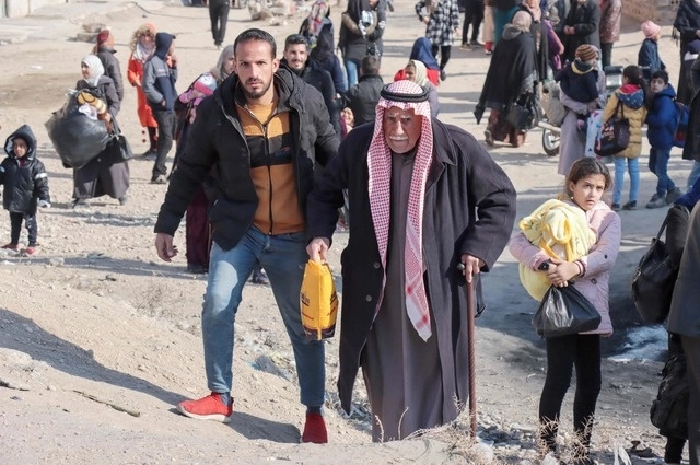 Sirios escapan de sus casas en el barrio de Ghwayran, después de días de combates entre el Estado Islámico y las fuerzas kurdas en Siria. Foto Afp 