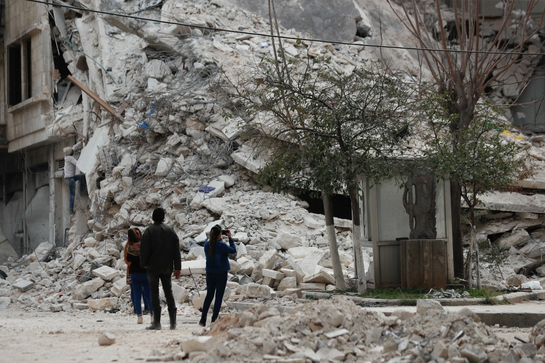 Personas observan un edificio derrumbado por el sismo de este lunes en Alepo, Siria. Foto Ap 