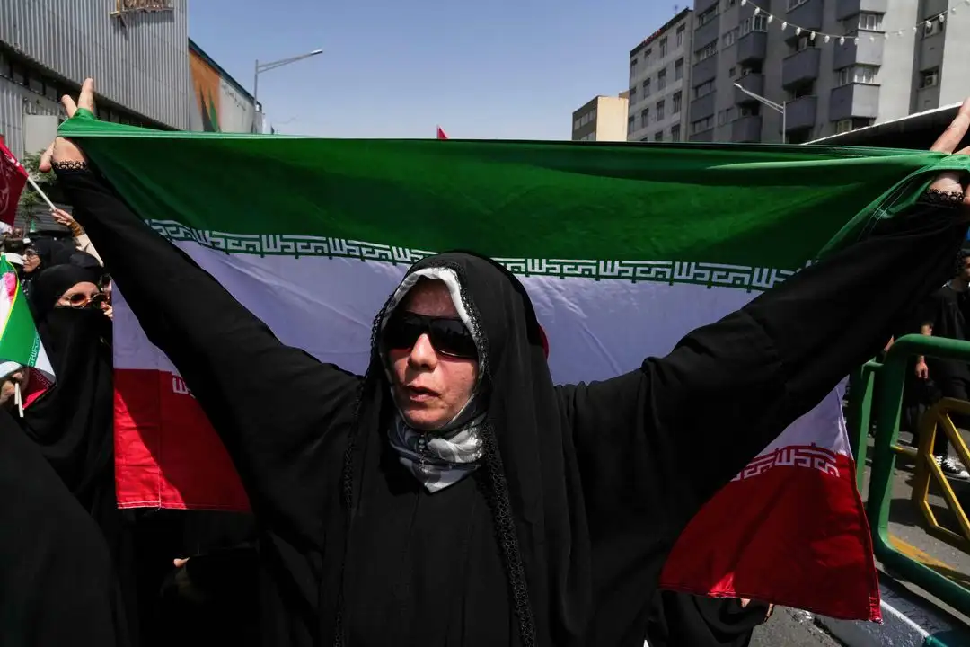 Una mujer iraní porta la bandera de su país durante una protesta para condenar los ataques israelíes, en Teherán, el 20 de junio de 2025. Foto 