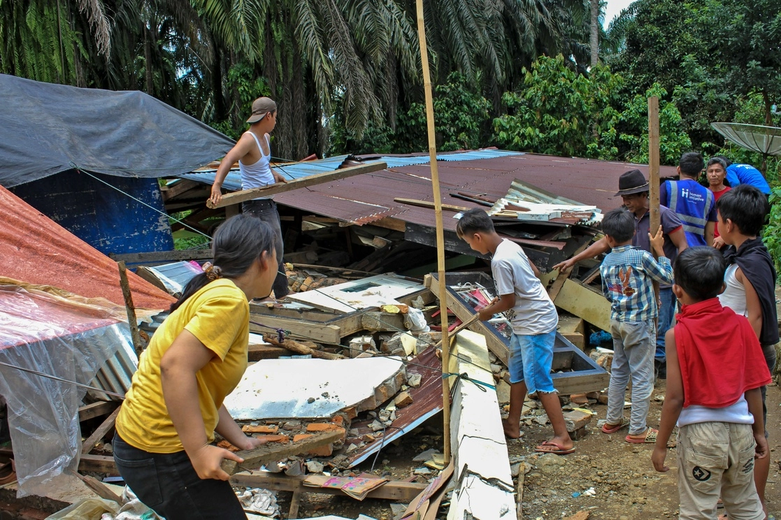 Habitantes de Sumatra limpian los escombros de una casa dañada tras el sismo registrado el 28 de febrero de 2022. Foto Ap