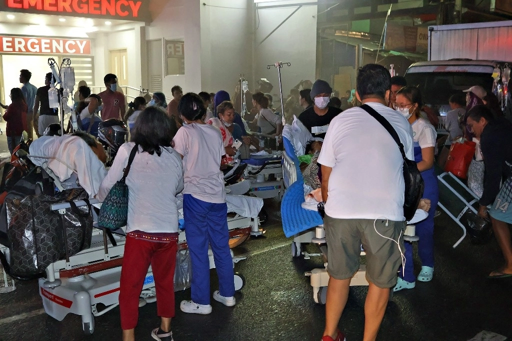 Residentes y el personal médico evacuan a los pacientes desde el interior de un hospital luego de que un terremoto de 7.6 sacudiera la ciudad de Butuan, en la isla sureña de Mindanao. Foto Afp / Ted Aljibe