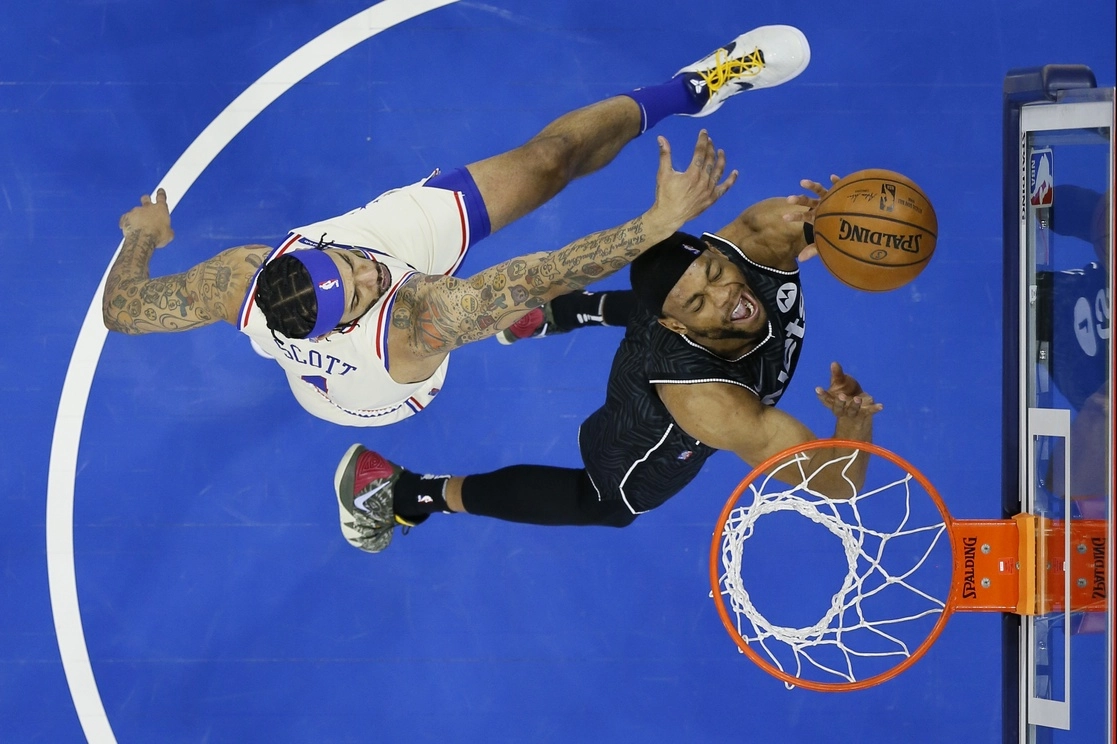 Bruce Brown de los Nets y Mike Scott de los 76ers durante el encuentro. Foto Ap