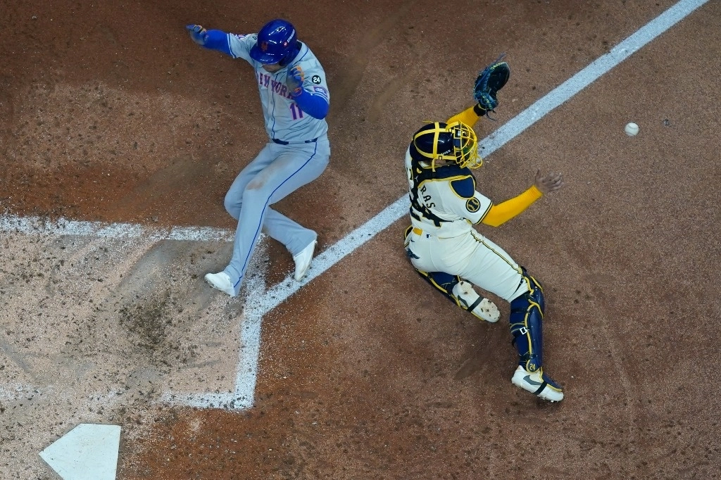 José Iglesias, de los Mets, anota ante el infructuoso esfuerzo del cácher de los Cerveceros, William Contreras. La plantilla neoyorquina se impuso 8-4 en el arranque de la ronda de comodines de los ‘playoffs’. Foto Ap 
