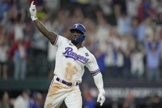 El beisbolista de los Rangers de Texas, Adolis García festeja tras anotar el cuadrangular del triunfo. Foto Ap