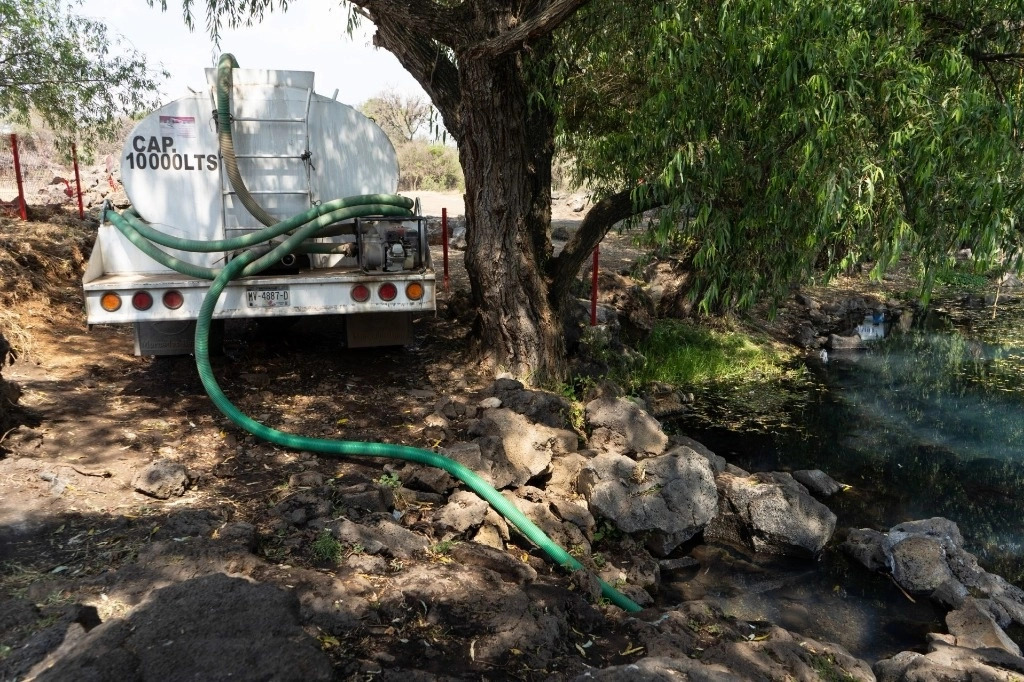 Una pipa de agua recarga líquido en el manantial Mintzinta. Foto Cuartoscuro / Archivo