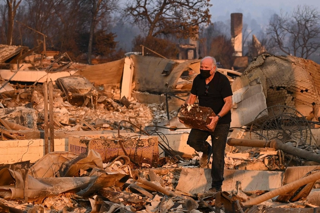 Un residente recupera una caja fuerte después de que su casa fuera destruida por el fuego en Los Ángeles, California. Foto Afp




