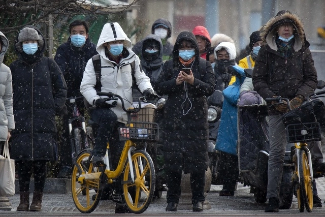 Personas caminan en la ciudad de Beijing, China. Foto Ap
