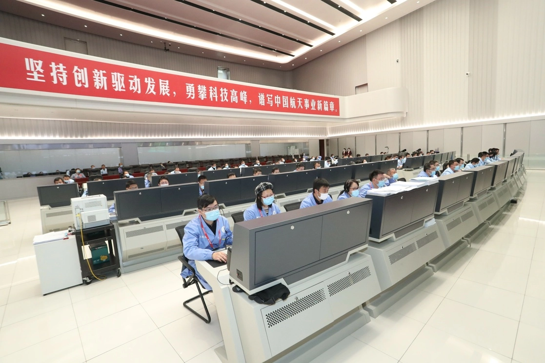 Personal técnico del Centro de Control Aeroespacial de Pekín. Antes de aluinzar, la sonda Chang'e-5 se desaceleró en dos ocasiones. Foto Xinhua