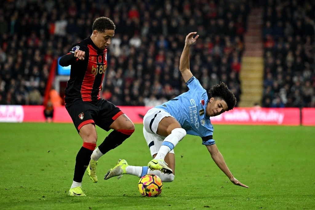 Marcus Tavernier (izquierda) del Bournemouth presiona la defensa  del balón que hace Rico Lewis del Manchester City. Foto Afp