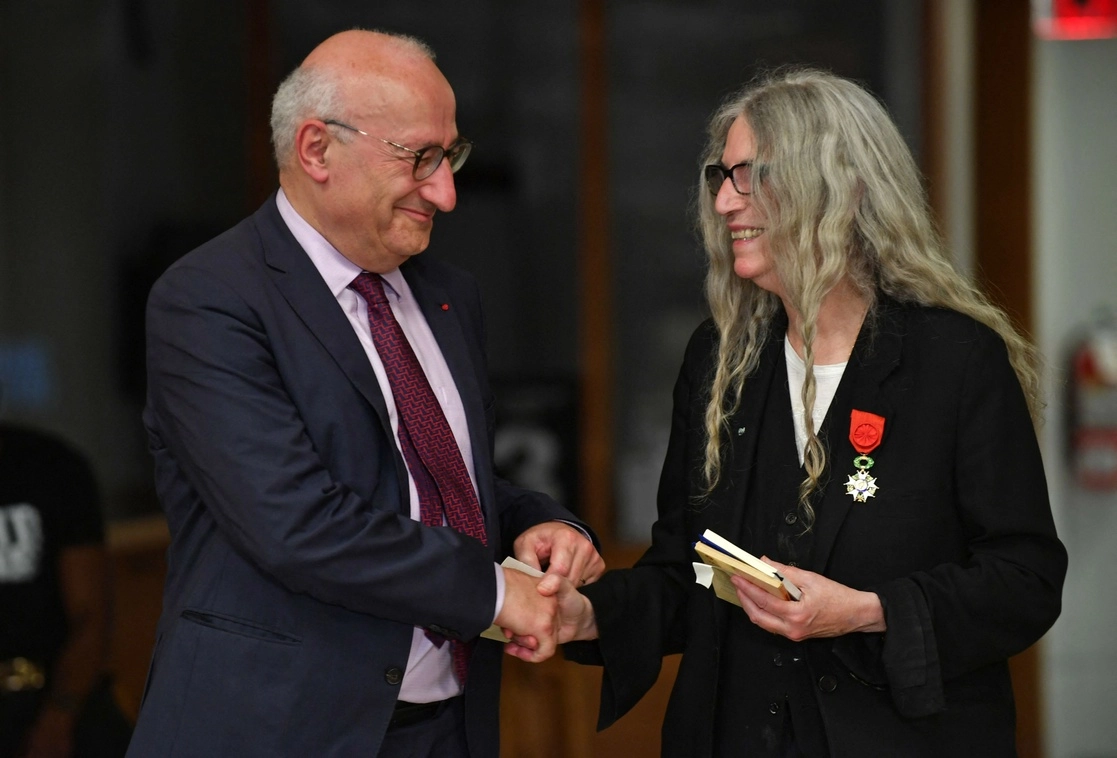 En la imagen, Philippe Etienne, embajador de Francia en Estados Unidos, y la cantautora estadunidense se dan la mano después de que ella recibió la más alta orden al mérito del país galo, en la Biblioteca Pública de Brooklyn en Nueva York. Foto Afp