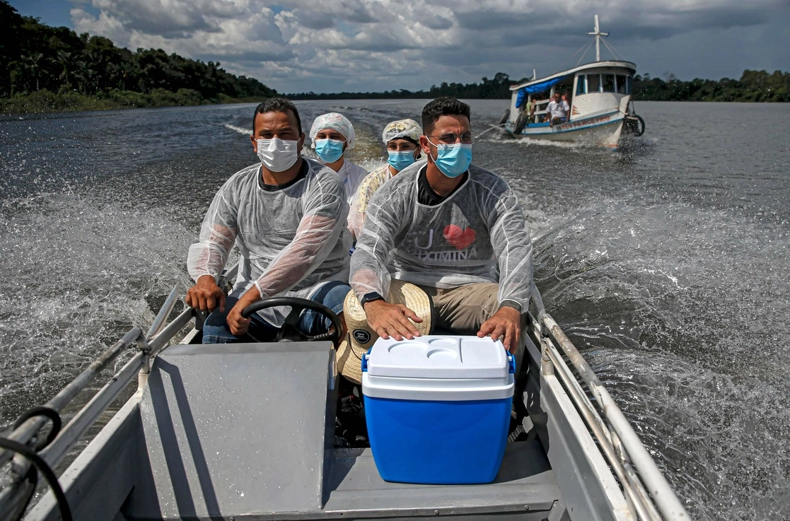 Trabajadores de la salud viajan por el río Erepecuru para vacunar a las comunidades quilombo –asentamientos de afrodescendientes del interior–, en el municipio de Oriximina, en la frontera entre los estados de Pará y Amazonas, Brasil. Foto Afp