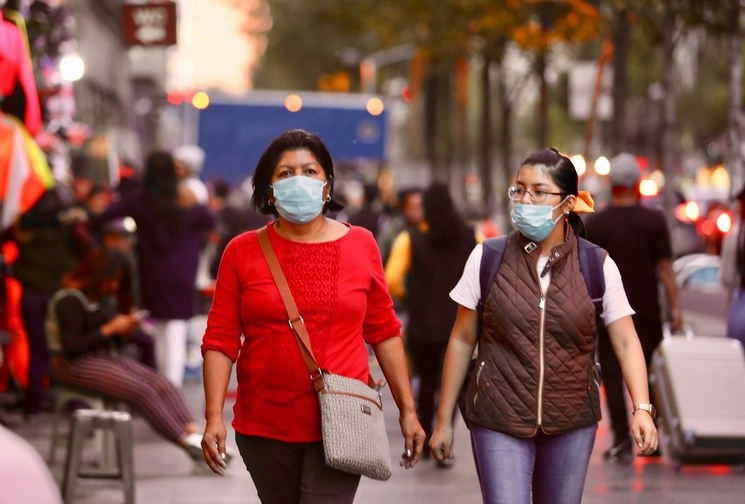 Mujeres utilizan cubrebocas a su paso por calles de la CDMX. Foto María Luisa Severiano 