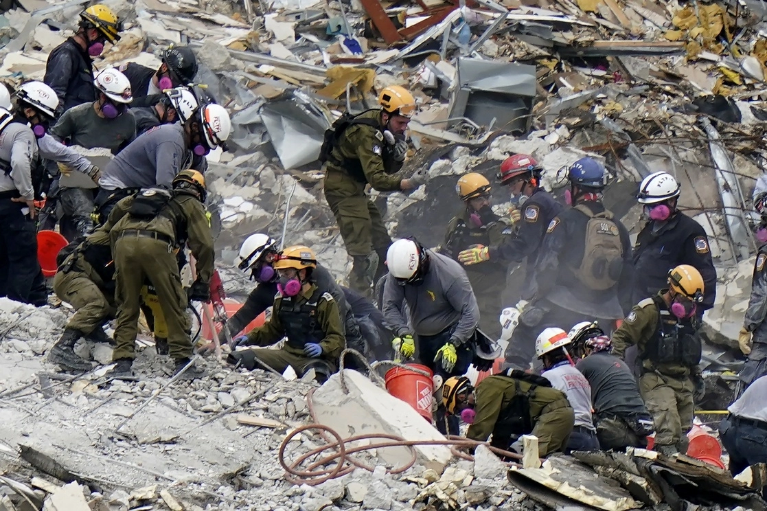 Brigadistas israelíes y estadunidenses realizan tareas de búsqueda en el edificio colapsado en Miami, Florida. Foto Ap 