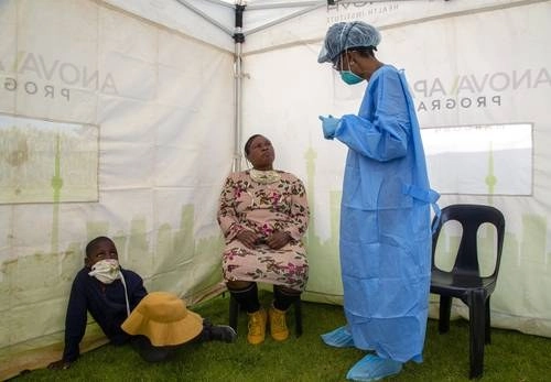 Una trabajadora sanitaria explica a una madre el procedimiento para una prueba de coronavirus. Foto Ap / Archivo