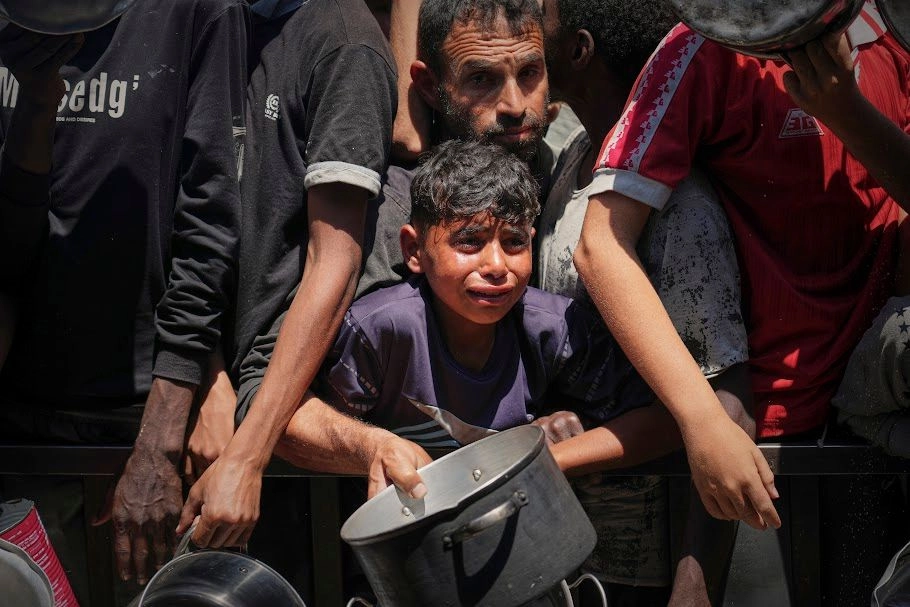 Niños palestinos buscan recibir comida en una cocina comunitaria en Jan Yunis, Gaza. Foto 