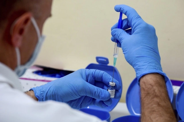Un trabajador de la salud prepara una dosis de la vacuna Pfizer/BioNTech en Hungría. Foto Ap 