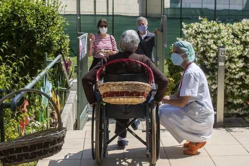 Carmela Bergamelli, de 87 años, habla con sus familiares a cierta distancia; está flanqueada por Maria Giulia Badaschi, directora del hogar de ancianos Fundación Martino Zanchi, en Alzano Lombardo, Italia. Foto Ap