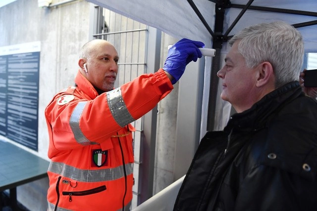 Revisan la temperatura de un hombre a la entrada de un estadio de futbol en Italia como medida de prevención ante el Covid-19. Foto Ap
