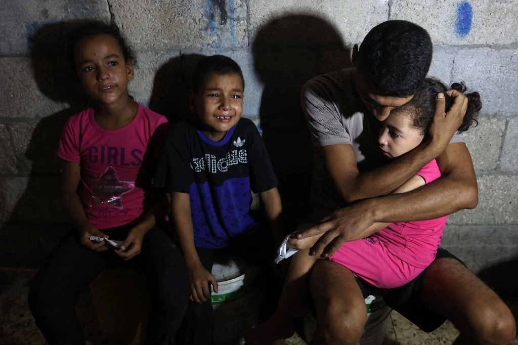 La familia palestina en la imagen recibió la noticia de la muerte de uno de sus integrantes durante el ataque israelí contra la escuela Amr Ibn, que albergaba a cientos de desplazados de la guerra. Foto Afp 