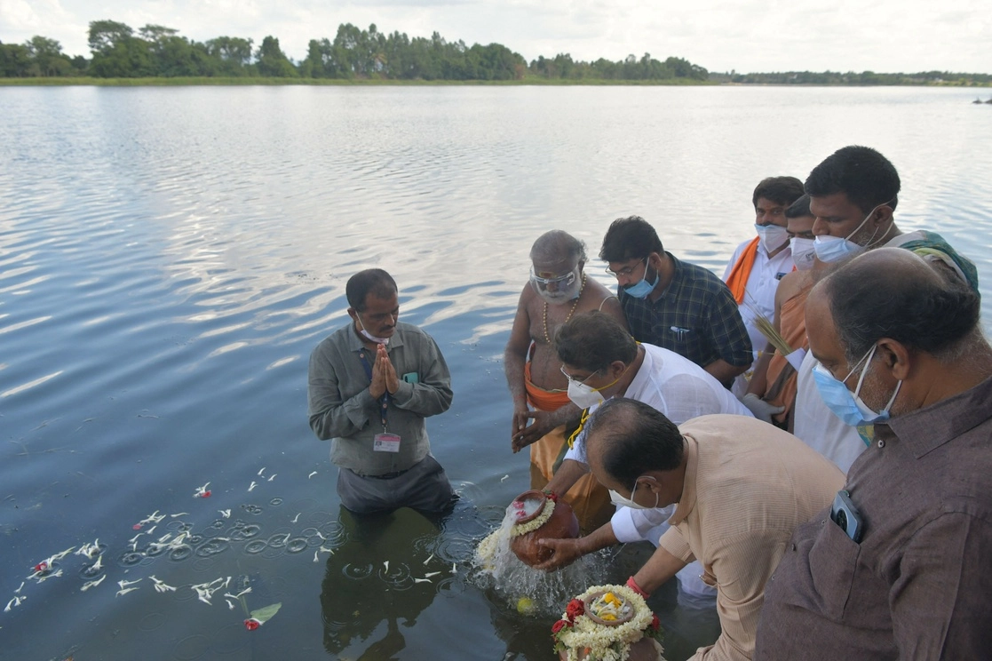 Autoridades sumergen simbólicamente en el río Cauvery, una urna de arcilla que contiene las cenizas de una persona que murió debido al Covid-19. Foto Afp