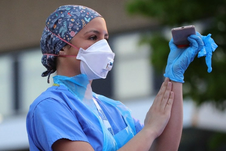 Una trabajadora del Servicio Nacional de Salud participa en la campaña semanal "Aplauso por nuestros cuidadores"
en el Hospital Real de Berkshire, Reino Unido. Foto Xinhua