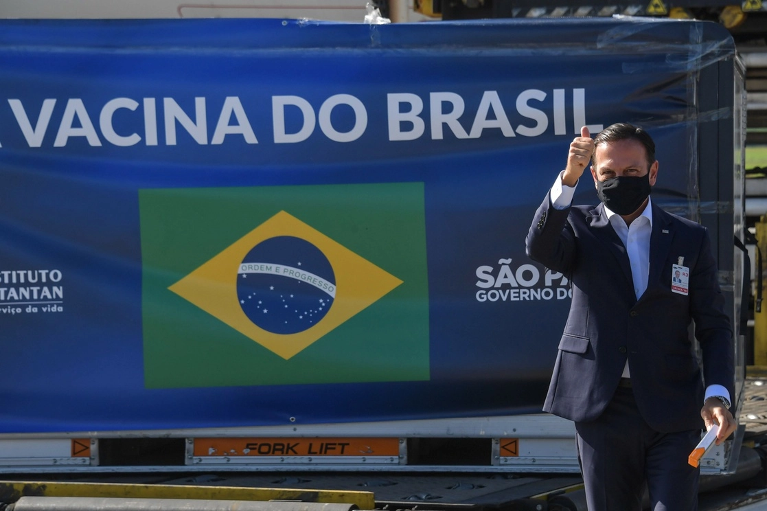 El gobernador de Sao Paulo, Joao Doria, posa con una publicidad de la vacuna que llegará a Brasil. Foto Afp