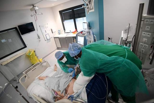 En imagen del 29 de diciembre de 2021, enfermeras atienden a un paciente de coronavirus en cuidados intensivos en un hospital de las afueras de París, en Francia. Foto Afp