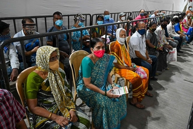 Personas esperan en fila para recibir la vacuna contra el coronavirus de Covishield, en Mumbai, India. Foto Afp 