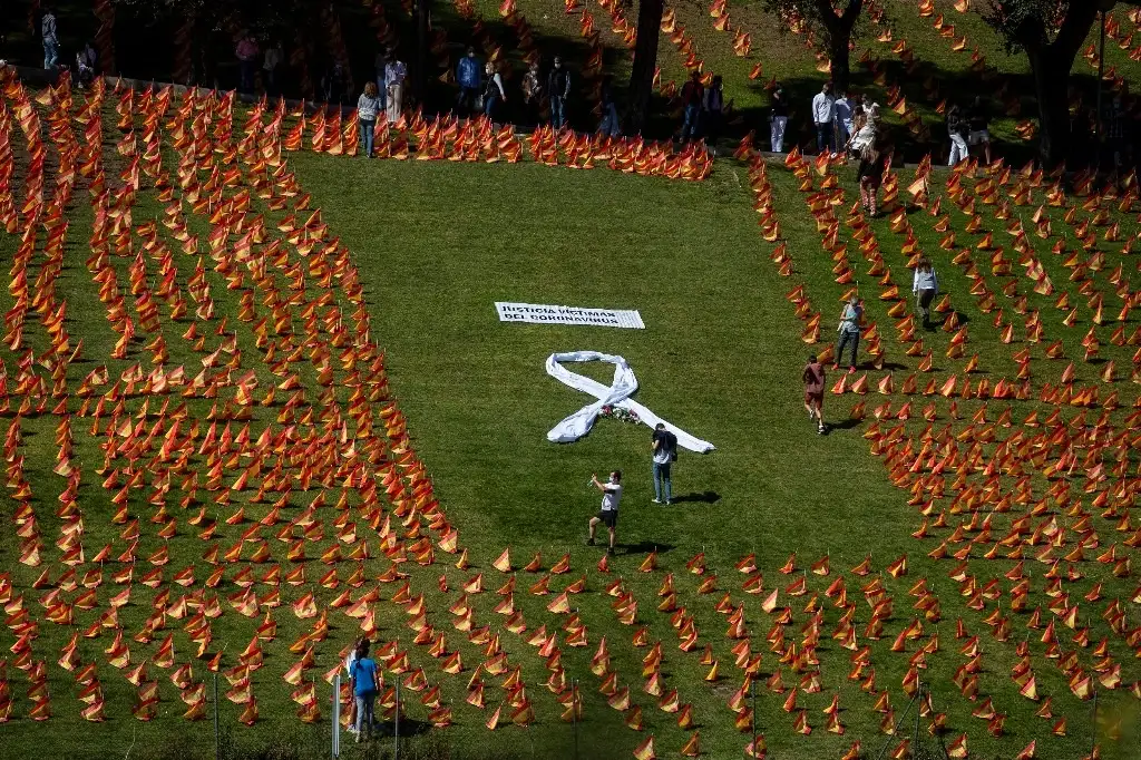 Una asociación de familias de víctimas del coronavirus colocaron 53 mil banderas españolas en un parque de la capital del país ibérico para honrar a sus muertos y exigir justicia. Foto Ap