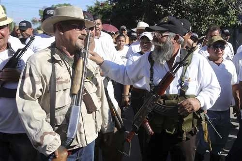 Los líderes de los grupos de autodefensas Hipólito Mora(izquierda) y Estanislao Beltrán, 'Papá Pitufo', durante la conmemoración del primer año de ese movimiento, el 24 febrero de 2014, cuando marcharon de la tenencia Felipe Carrillo Puerto, mejor conocida como La Ruana, en el municipio de Buenavista Tomatlán, hacia la plaza principal. Foto Ignacio Juárez