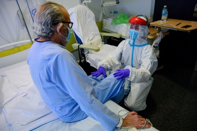 Un fisioterapista atiende a un paciente que se recuperó de coronavirus en un hospital cerca de Madrid, España. Foto Afp