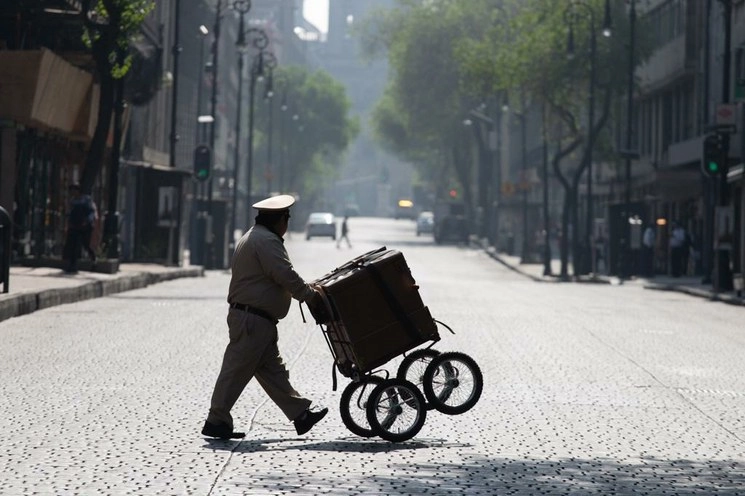 Un organillero atraviesa la calle 5 de Mayo, ahora vacía, durante la segunda semana de la Jornada Nacional de Sana Distancia, en el Centro Histórico. Foto Pablo Ramos