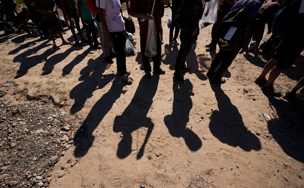 Migrantes esperan a ser procesados por agentes de la Patrulla Fronteriza después de cruzar el Río Grande desde México, en Eagle Pass, Texas. Foto Ap / Archivo