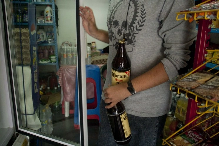 Persona adquiere bebidas alcohólicas de Grupo Modelo en imagen de archivo. Foto Cuartoscuro