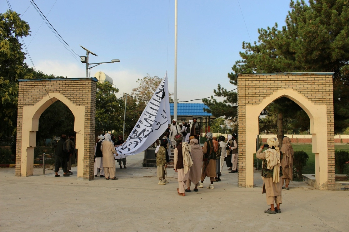 Combatientes talibanes izan su bandera en la casa del gobernador de Ghazni, al sureste de Afganistán. Foto Ap