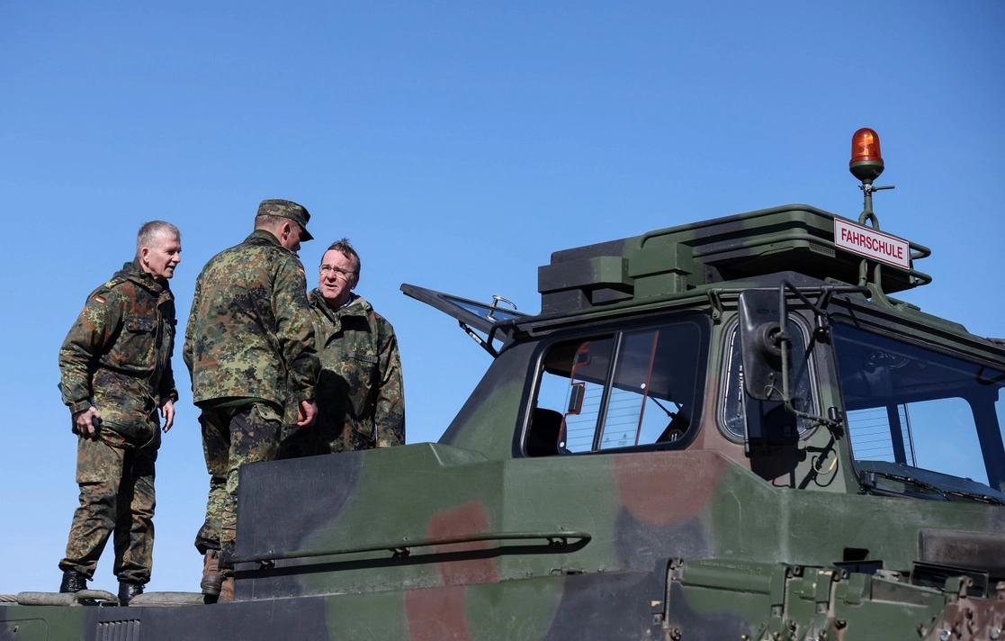 El ministro alemán de Defensa, Boris Pistorius (extremo derecho), y el teniente general Martin Schelleis, del ejército alemán (a la izquierda), captados sobre la base de un tanque ‘Leopard 2’ que sirve de escuela de manejo, en un área de entrenamiento militar en Mahlwinkel, cerca de Magdeburg, Alemania, hace unos días. Foto Afp