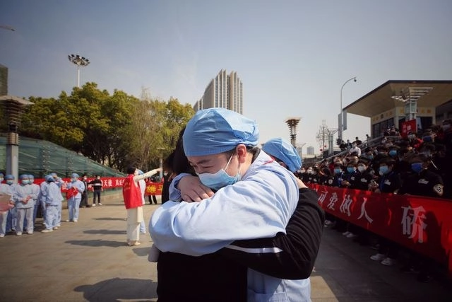 Un médico abraza a su equipo de asistentes de Jiangsu, durante una ceremonia antes de volver a sus casas, tras haber ayudado en la crisis del coronavirus en Wuhan, China. Foto Afp